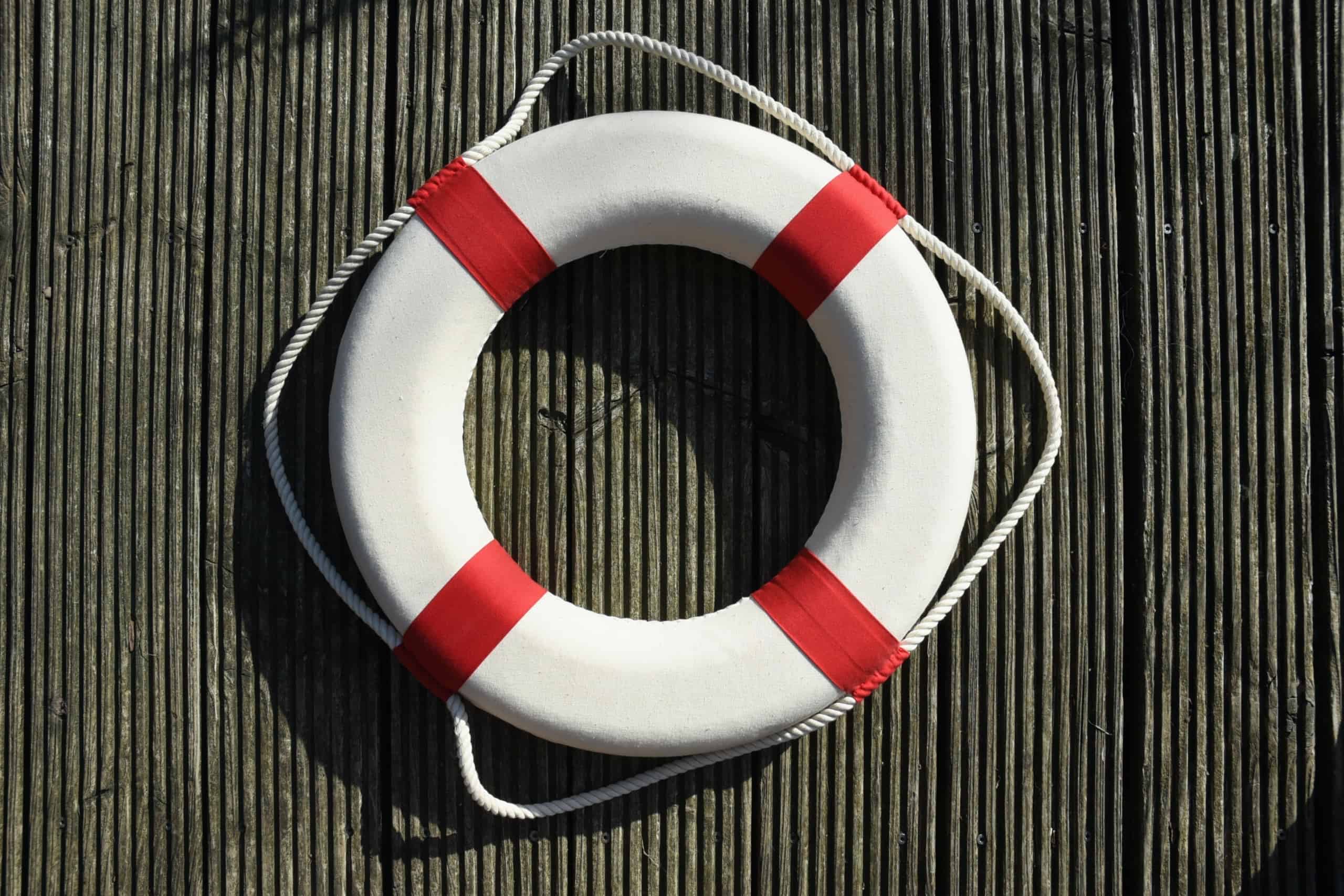 A lifesaver hanging on wooden board.
