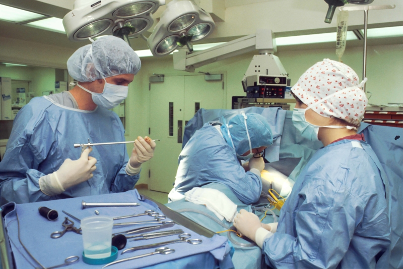 Operating Room. Two surgeons and a nurse performing a Thoracoscopy by which they are examining the pleural cavity by means of an Endoscope to later perform a biopsy.