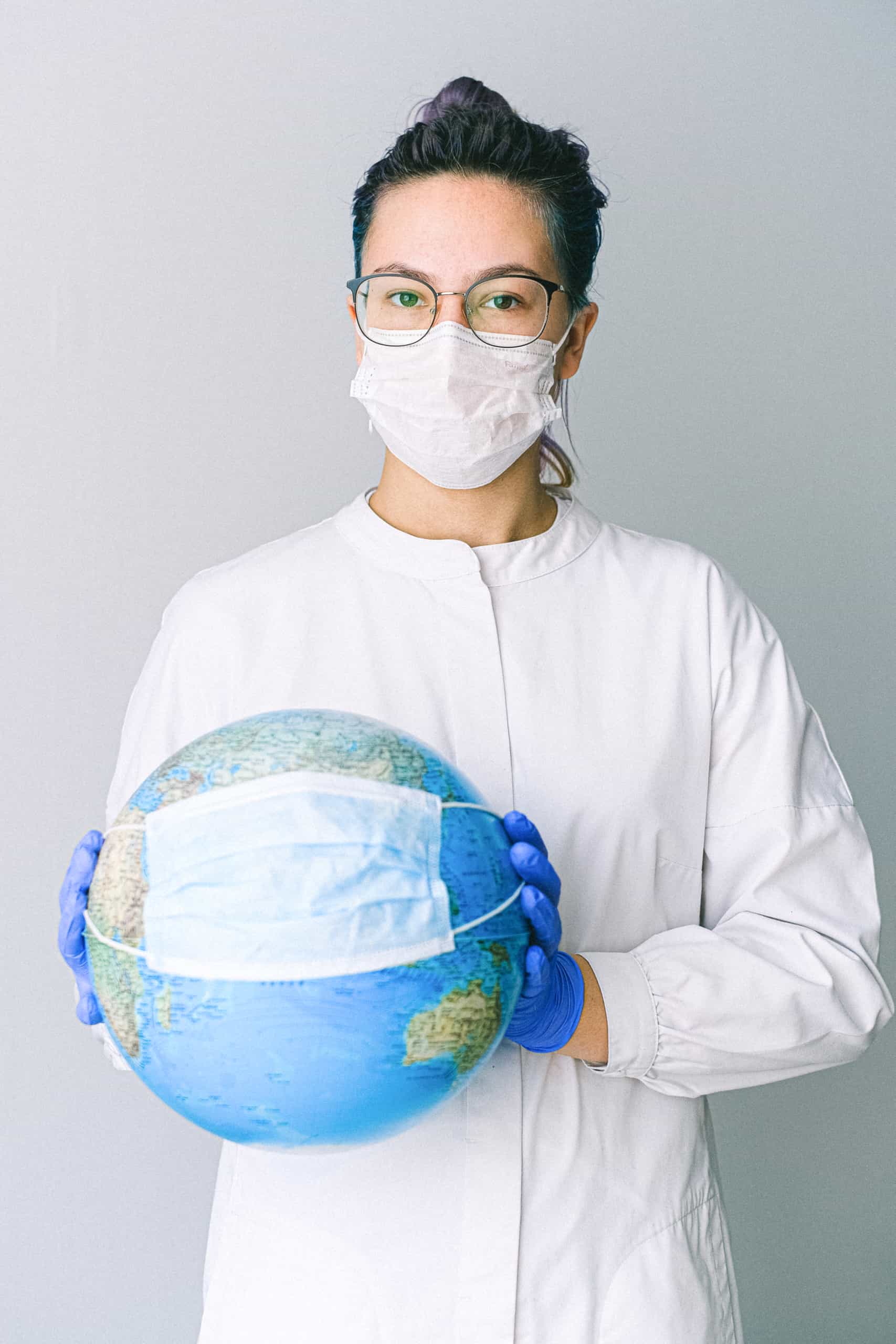 Photo of person wearing protective wear while holding globe