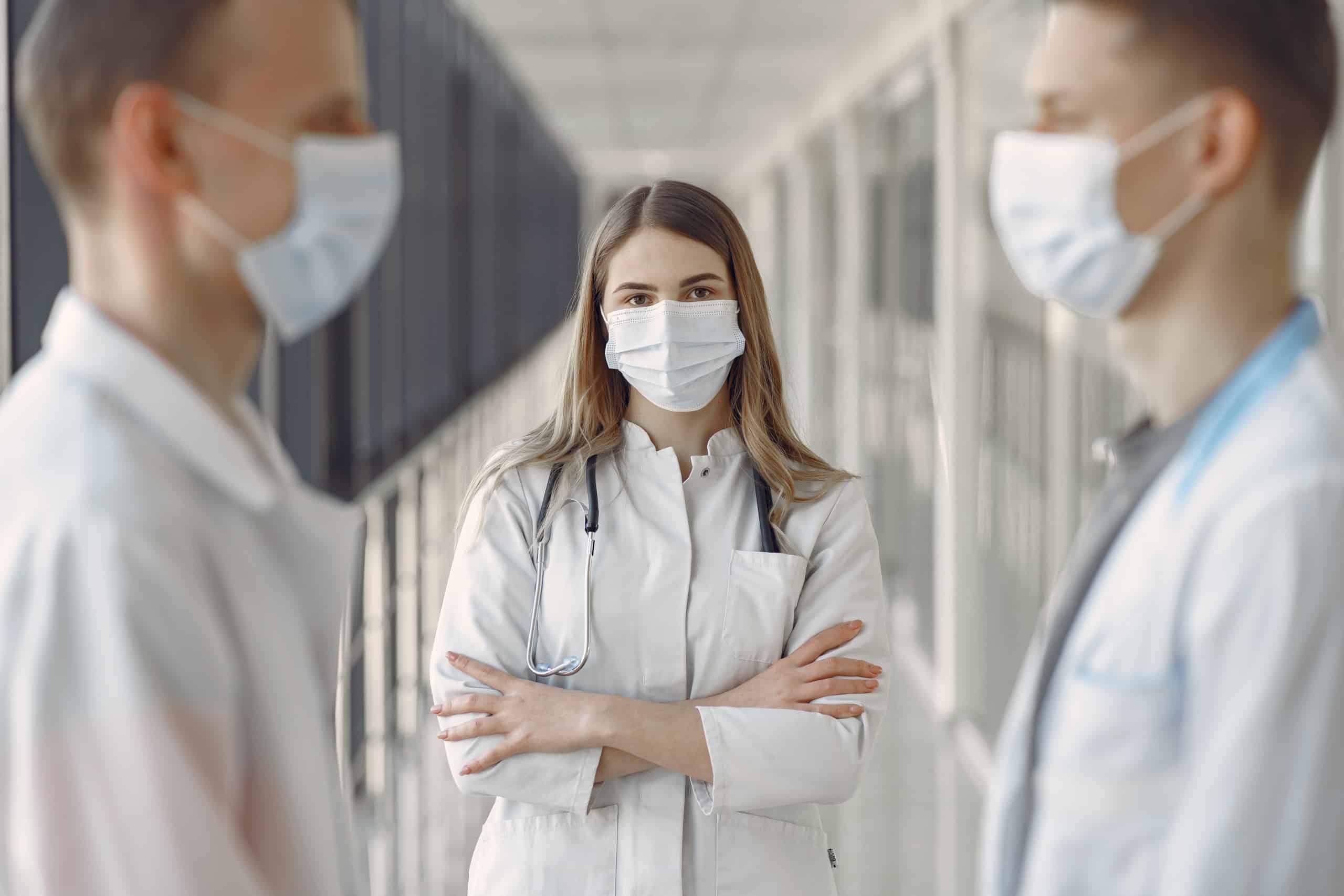 Woman in white coat wearing white face mask