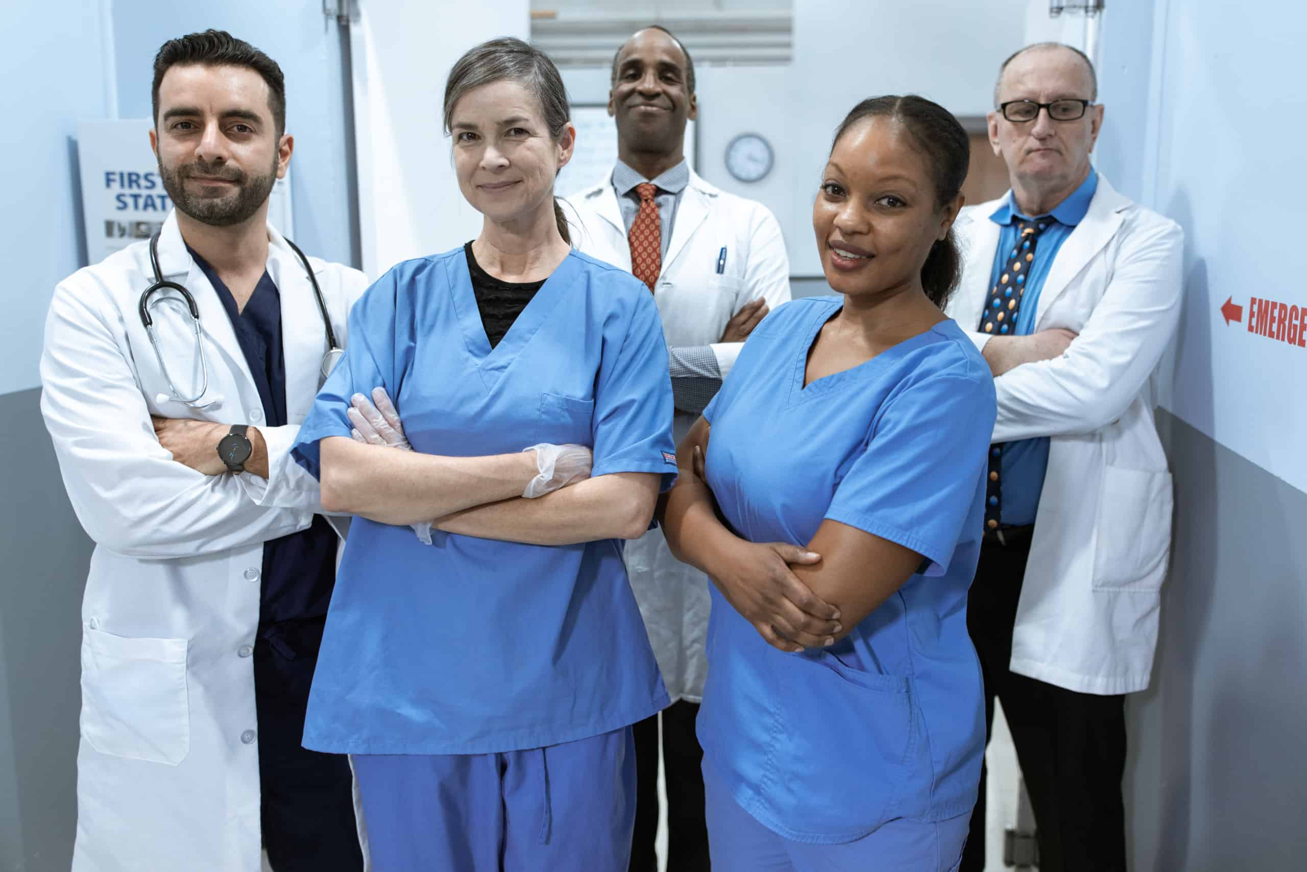 Woman in blue scrub suit standing beside woman in white scrub suit
